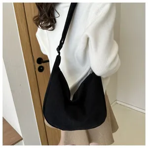 Detailed view of the black corduroy crescent bag showing fabric texture and wide strap