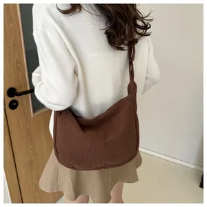 Brown corduroy crossbody bag shown on a model with a casual minimalist outfit