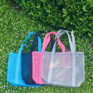 Mesh beach tote bags set of four in blue black pink and grey on a green grass field