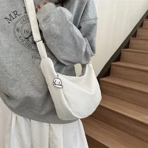 White corduroy half-moon crossbody bag with a cute puppy pendant on a wide shoulder strap
