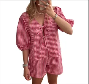 Detail of red gingham two-piece set featuring puff sleeves and front tie bow closure