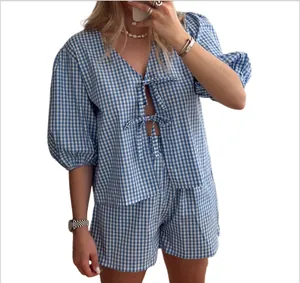 Detail of blue and white gingham summer set with V-neck bow-tie top and matching shorts