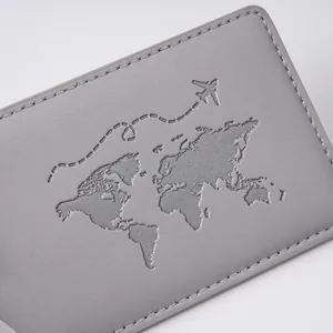 Detailed view of silver-gray passport cover with embossed world map and airplane design