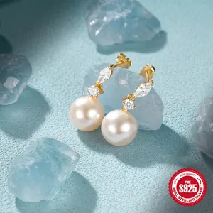 Detail of S925 sterling silver pearl earrings with zircons on blue background