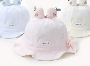 Detailed view of baby sun hats with pineapple texture, bows and ruffle edge design