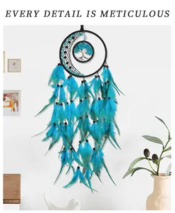 Detail of moon shaped dream catcher with tree of life design and peacock blue feathers