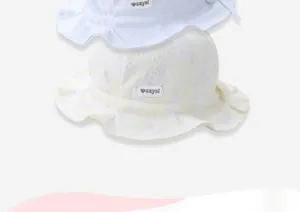 Detail of baby sun hat showing pineapple jacquard texture and scalloped wavy brim