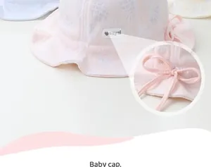 Close-up of pink baby sun hat with white pineapple print and side bow decoration