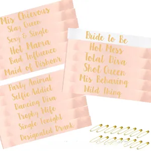 Detail view of rose gold satin bachelorette sashes with gold foil text and safety pins