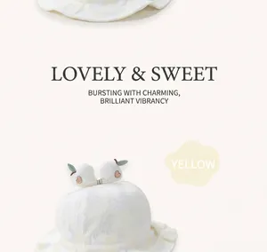 Close-up of yellow baby sun hat with pineapple pattern and cute fruit bow detail