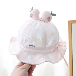 Pink cotton baby sun hat with white pineapple prints and a peach topper decoration