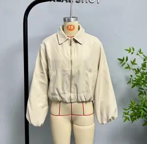 Détail de la veste zippée beige montrant le col à revers et l'ourlet élastique