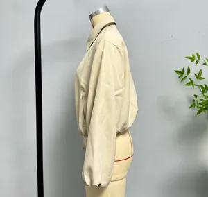 Vue latérale de la veste courte beige avec col à revers et poignets élastiques