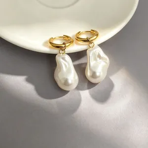 18K gold plated stainless steel hoop earrings with large baroque pearls on a white plate
