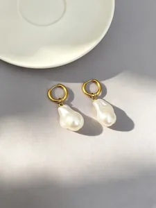 Detailed macro view of 18k gold plated hoop earrings with irregular baroque pearls