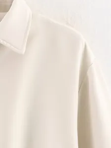 Gros plan sur le col d'une veste crème montrant la texture du tissu et les finitions