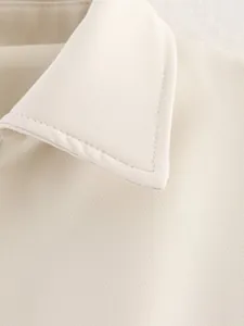 Détail du col à revers beige avec coutures précises sur une veste matelassée