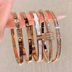 Luxury rose gold titanium bangles set with roman numerals and sparkling cubic zirconia