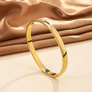 Detailed close-up of 18k gold-plated stainless steel bangle with polished mirror finish