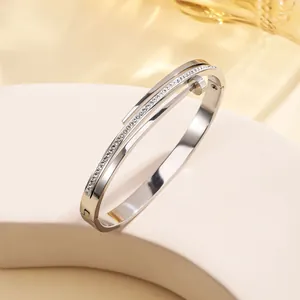 Close-up of double-layer stainless steel bangle with pavé-set zircons and polished finish