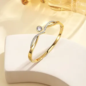 Close-up of 18k gold plated bangle with sparkling main crystal and pavé diamond details