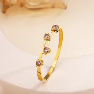 Detailed close-up of 18k gold plated stainless steel bangle with pink heart zircons