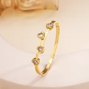 Macro shot of 18k gold plated titanium steel bangle featuring four heart-cut crystal stones