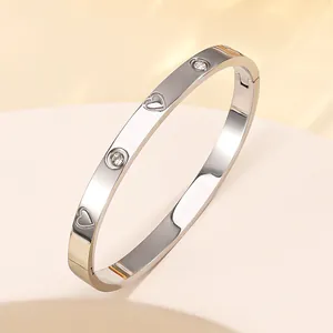 Macro detail of silver titanium steel bracelet with heart cutouts and inlaid diamonds