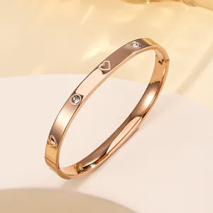 Detail of rose gold stainless steel bracelet with engraved hearts and cubic zirconia