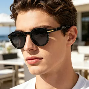 Detail of vintage round black sunglasses with golden arrow metal decor on the side