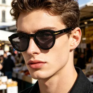 Retro round frame sunglasses with gold wing hinge detail worn by a male model outdoors