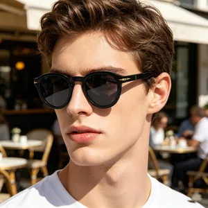 Detail of round retro sunglasses featuring gold arrow accents on black frames worn by model