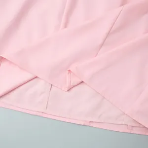 Close-up of pink sleeveless dress hem featuring precise double-fold stitching detail