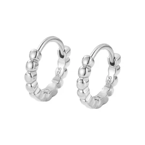 Détail macro de créoles en argent sterling S925 avec finition texturée perlée