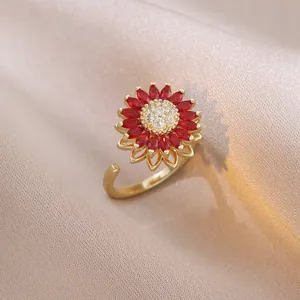 Macro shot of gold sunflower ring featuring red marquise stones and zircon center