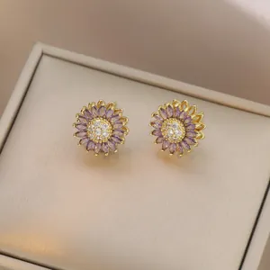 Detail of purple marquise-cut zircon daisy stud earrings with a golden metal base