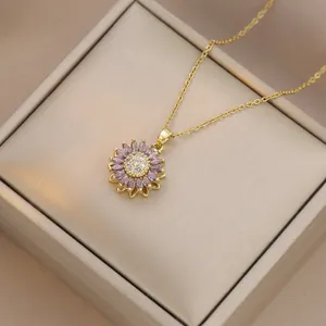 Detail view of purple sunflower pendant necklace with gold chain on a jewelry box lid