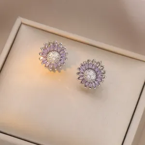 Detailed view of silver flower stud earrings with purple and white crystal petals