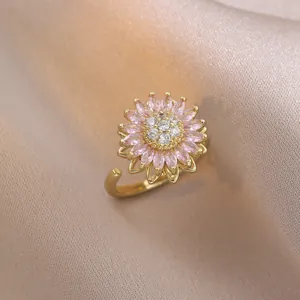 Detailed view of rotating sunflower ring with pink crystal petals and pavé diamond center