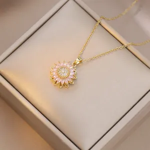 Detail of sunflower pendant necklace with pink rhinestones on a gold jewelry box