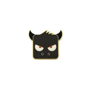 Cute black enamel monster pin with gold edges and red eyes on white background