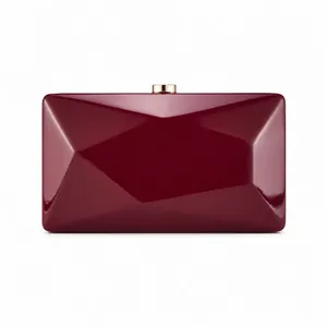 Detail view of burgundy evening clutch with geometric diamond-cut texture and gold clasp