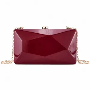 Detail of burgundy geometric evening clutch bag with gold chain and diamond pattern