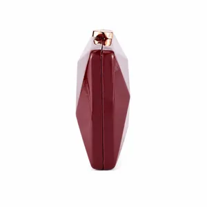 Side view of wine red geometric clutch bag with glossy finish and rose gold metal clasp