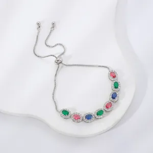 Adjustable silver bracelet featuring colorful oval crystals and zircon accents on a white board