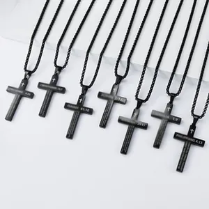 Macro detail of matte black stainless steel cross pendants with engraved bible verses