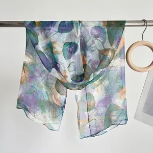 Detail of thin lightweight scarf featuring artistic leaf patterns and soft edging finish