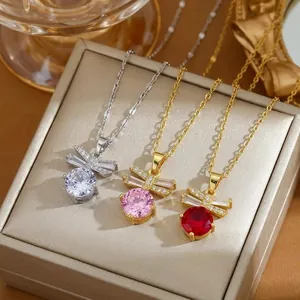 Detailed view of three bow necklaces with zircon stones on an elegant jewelry box