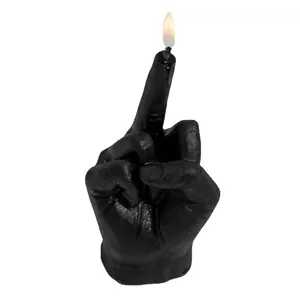Creative black middle finger gesture candle with a burning flame on a white background