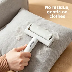 Close-up of ecoco lint roller removing hair and debris from gray fabric upholstery